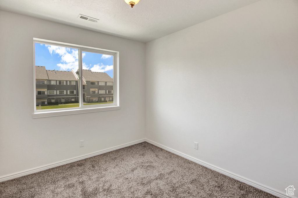 Unfurnished room featuring carpet floors and baseboards