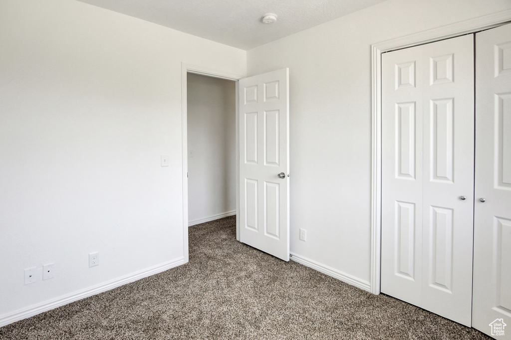 Unfurnished bedroom with carpet and a closet