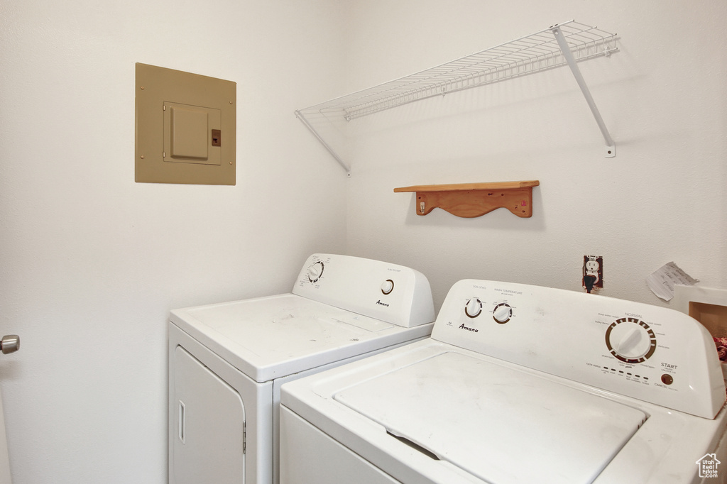 Laundry room featuring electric panel and washing machine and dryer