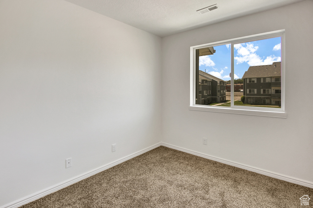 Empty room with carpet and baseboards
