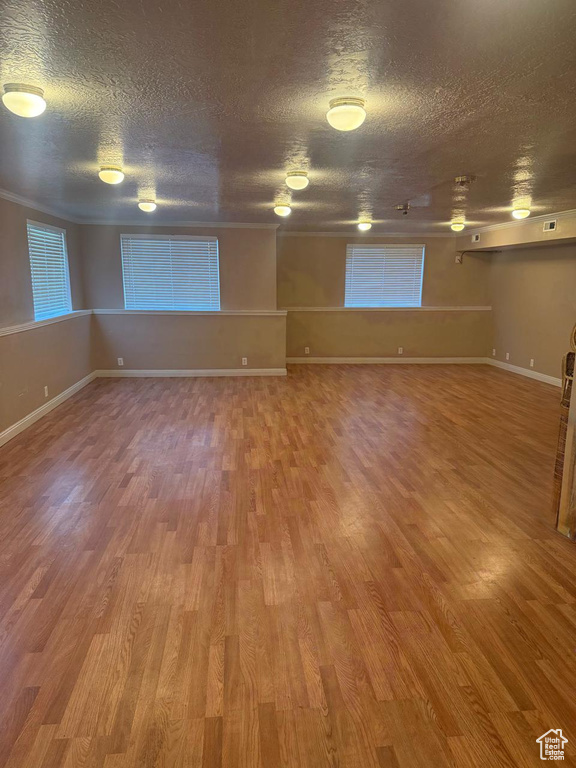 Unfurnished room featuring wood finished floors and a textured ceiling