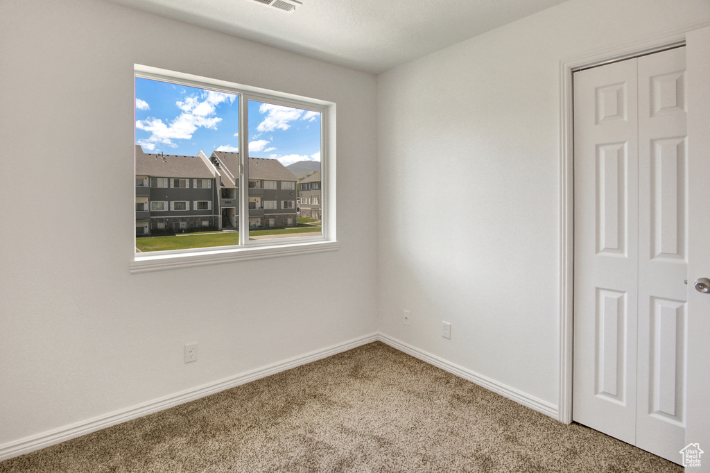 Unfurnished room featuring carpet floors and baseboards