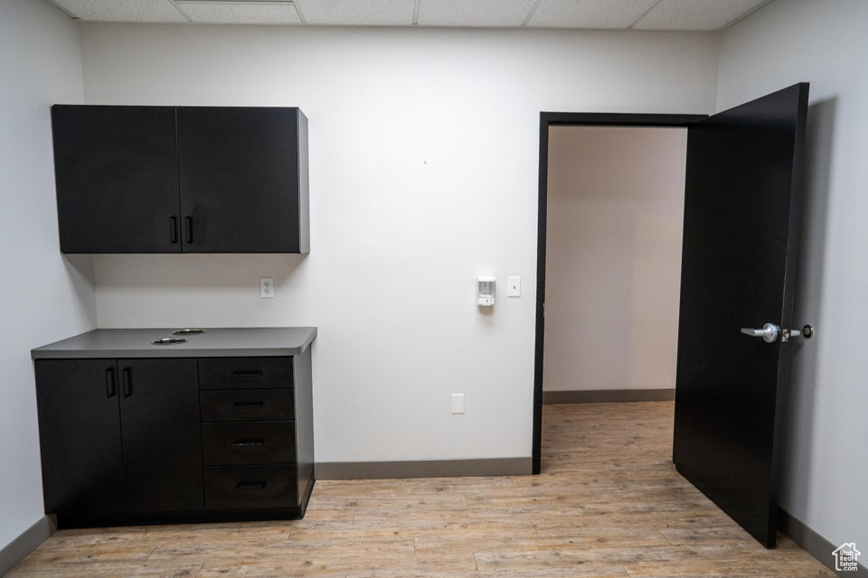 Unfurnished bedroom with a drop ceiling and light wood-style floors