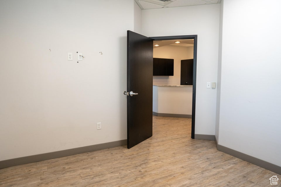 Spare room featuring light wood-style flooring and baseboards