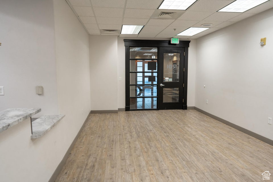 Spare room featuring wood finished floors and a drop ceiling