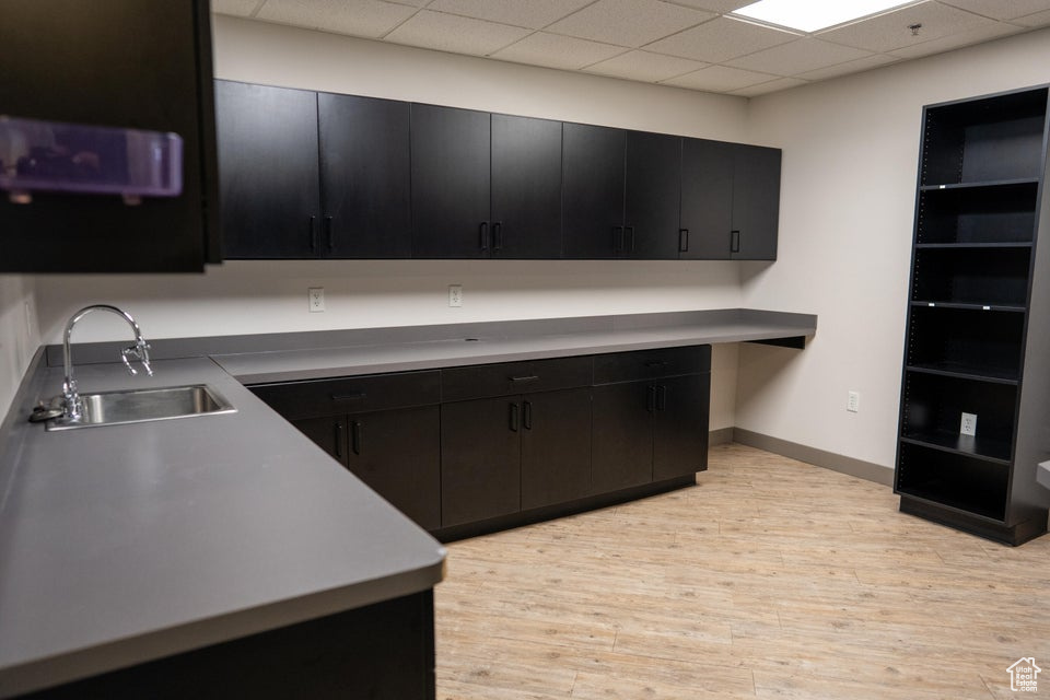 Kitchen featuring dark cabinetry, light wood-type flooring, and built in study area