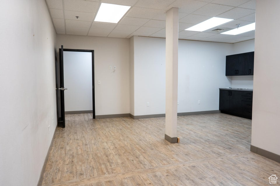 Below grade area featuring a paneled ceiling and wood finished floors