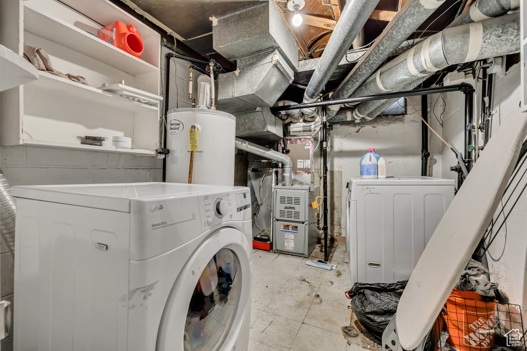 Unfinished basement with electric water heater, heating unit, and washer and clothes dryer