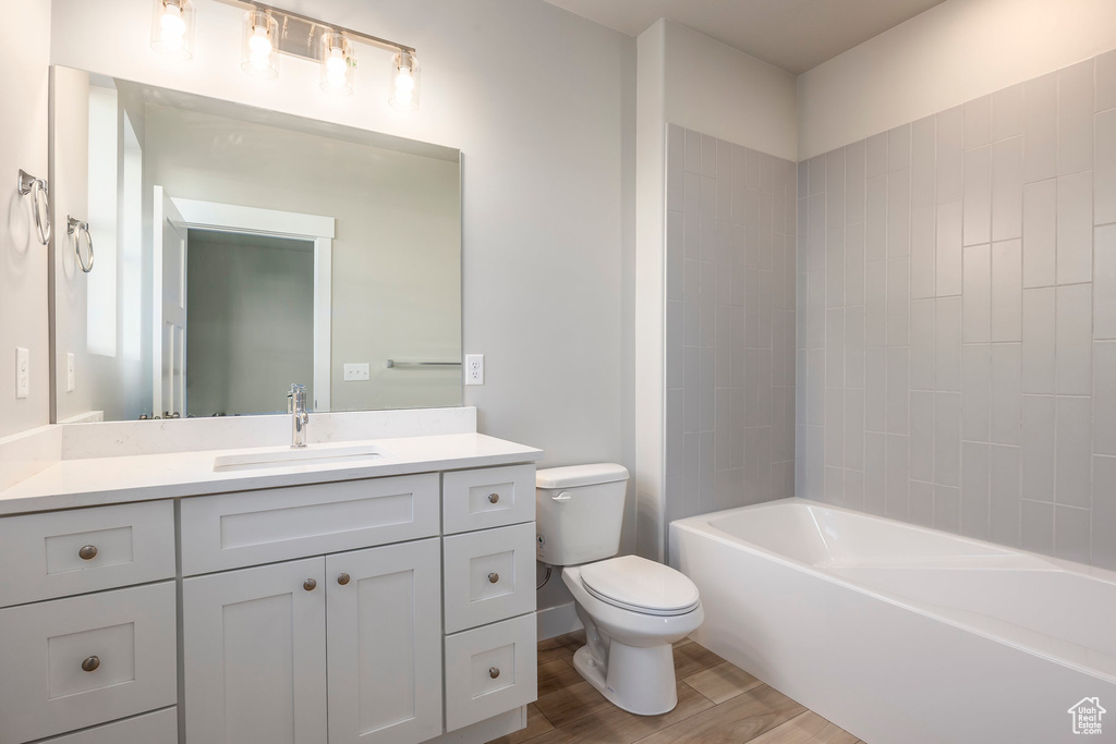 Full bathroom featuring vanity, wood finished floors, and shower / tub combination