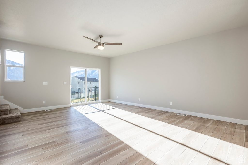 Spare room with light wood-style flooring, healthy amount of natural light, and a ceiling fan
