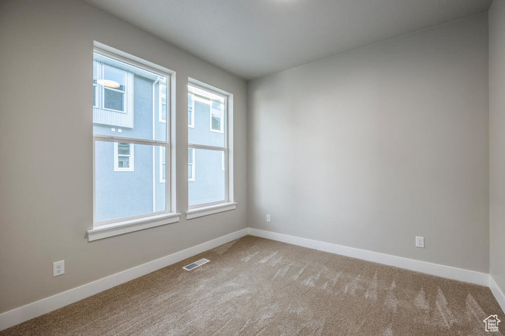 Carpeted empty room with healthy amount of natural light