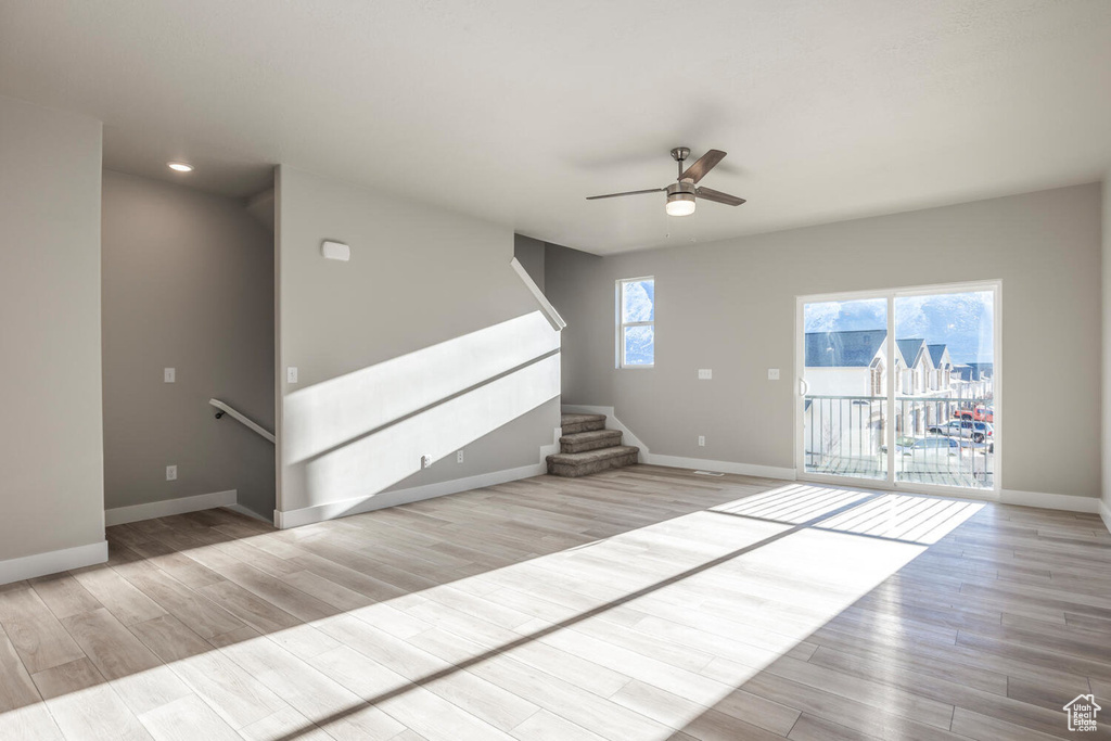 Unfurnished living room with ceiling fan, wood finished floors, stairs, and recessed lighting