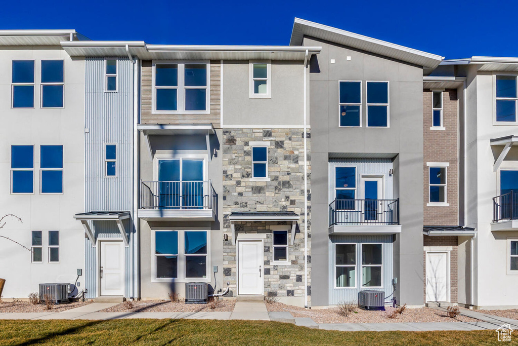 Townhome / multi-family property featuring stone siding and stucco siding