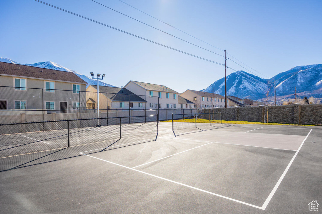 View of tennis court with a mountain view and community basketball court