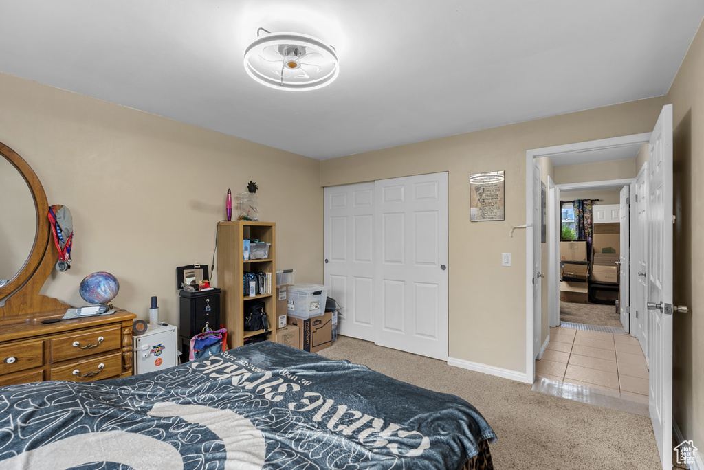 Carpeted bedroom with a closet and tile patterned flooring