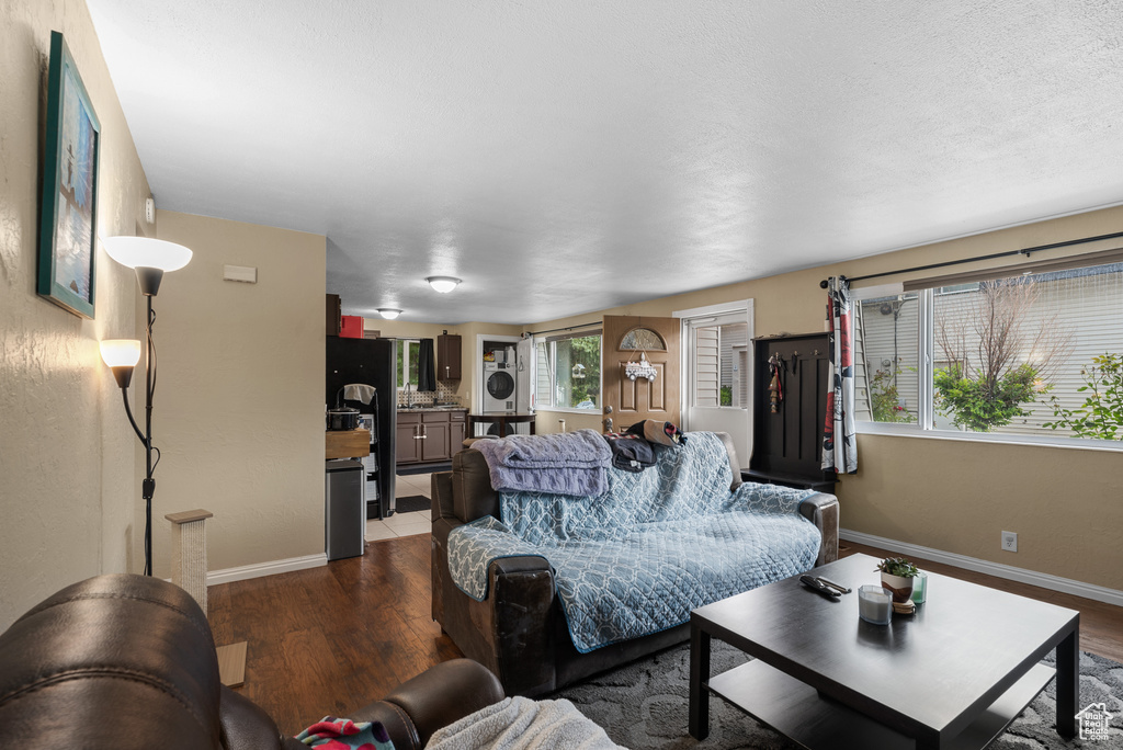 Living room featuring dark wood-type flooring and stacked washing machine and dryer