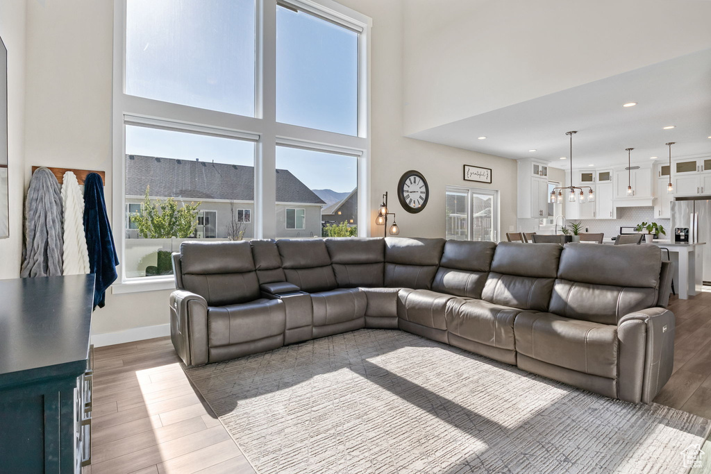 Living area featuring wood finished floors, recessed lighting, and a towering ceiling
