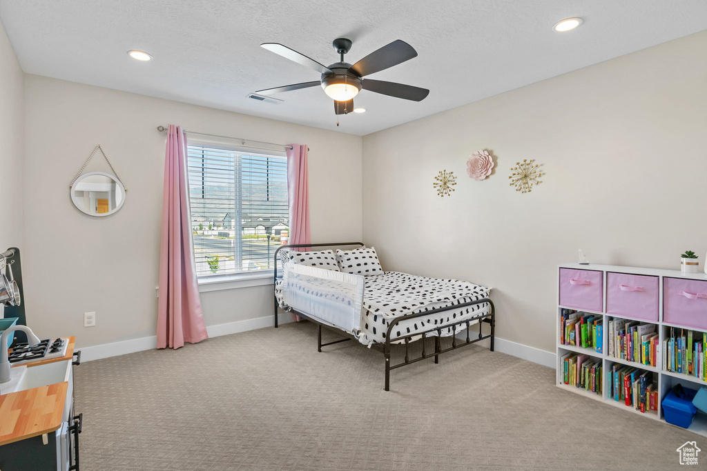Carpeted bedroom featuring ceiling fan and recessed lighting