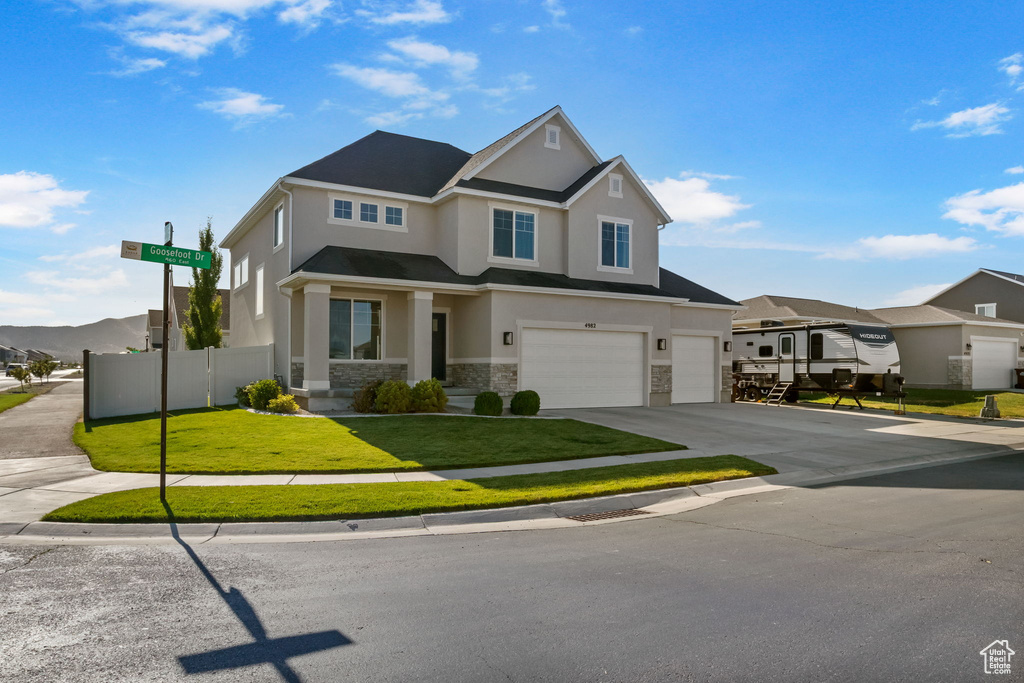 View of front of house featuring stucco siding, an attached garage, stone siding, and concrete driveway