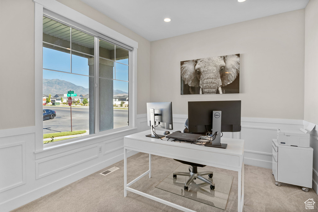 Office space with light colored carpet, a wainscoted wall, recessed lighting, and a decorative wall