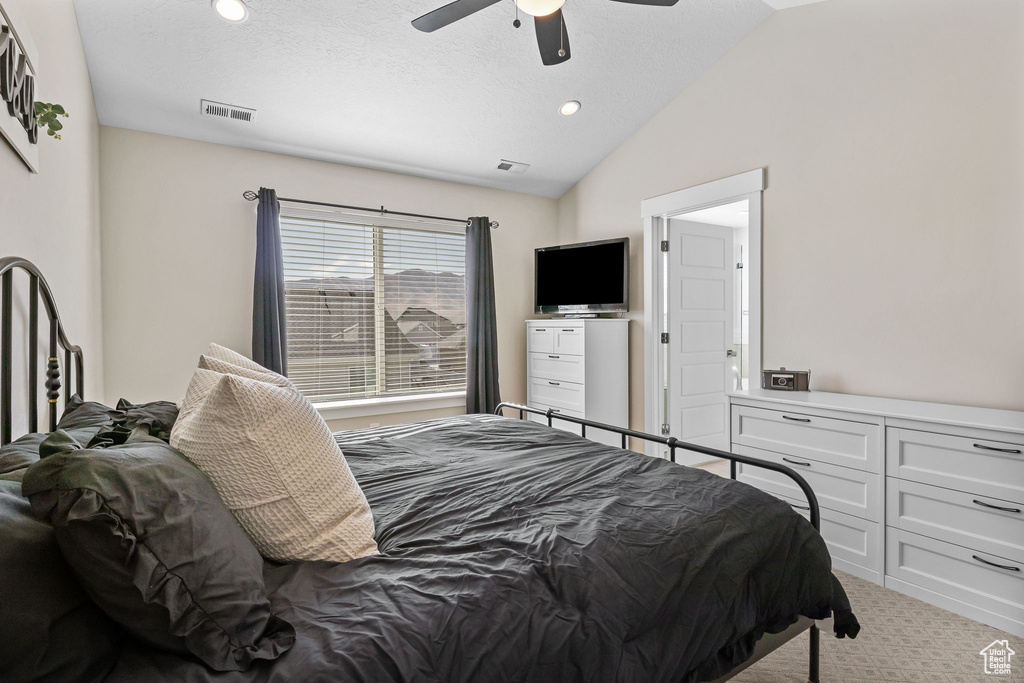 Carpeted bedroom featuring vaulted ceiling, a ceiling fan, and recessed lighting
