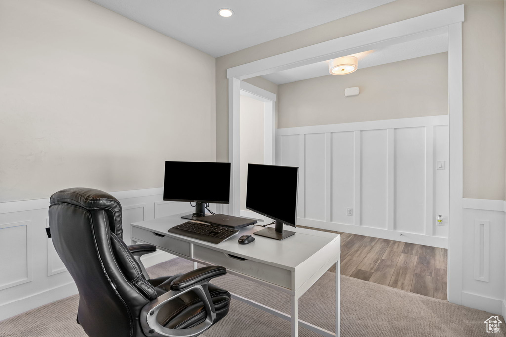 Office featuring a decorative wall, wainscoting, light wood-type flooring, and recessed lighting