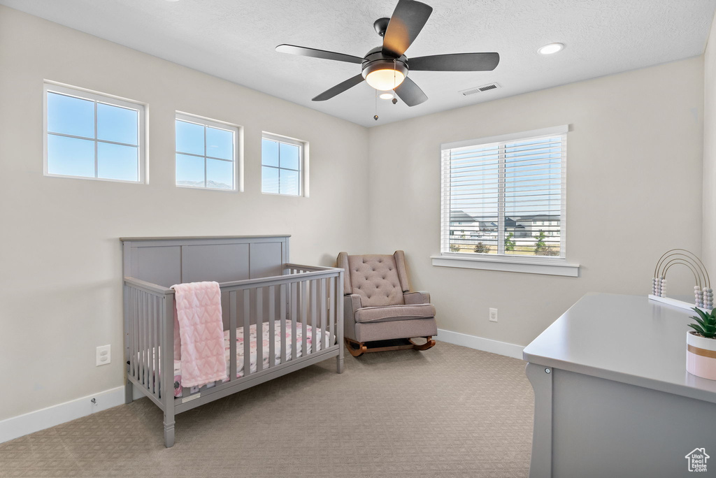 Bedroom with carpet floors, a crib, recessed lighting, and a ceiling fan