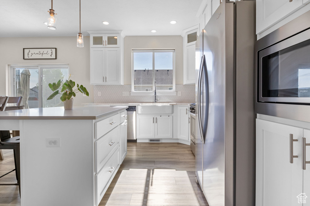 Kitchen with appliances with stainless steel finishes, a breakfast bar area, a kitchen island, plenty of natural light, and recessed lighting