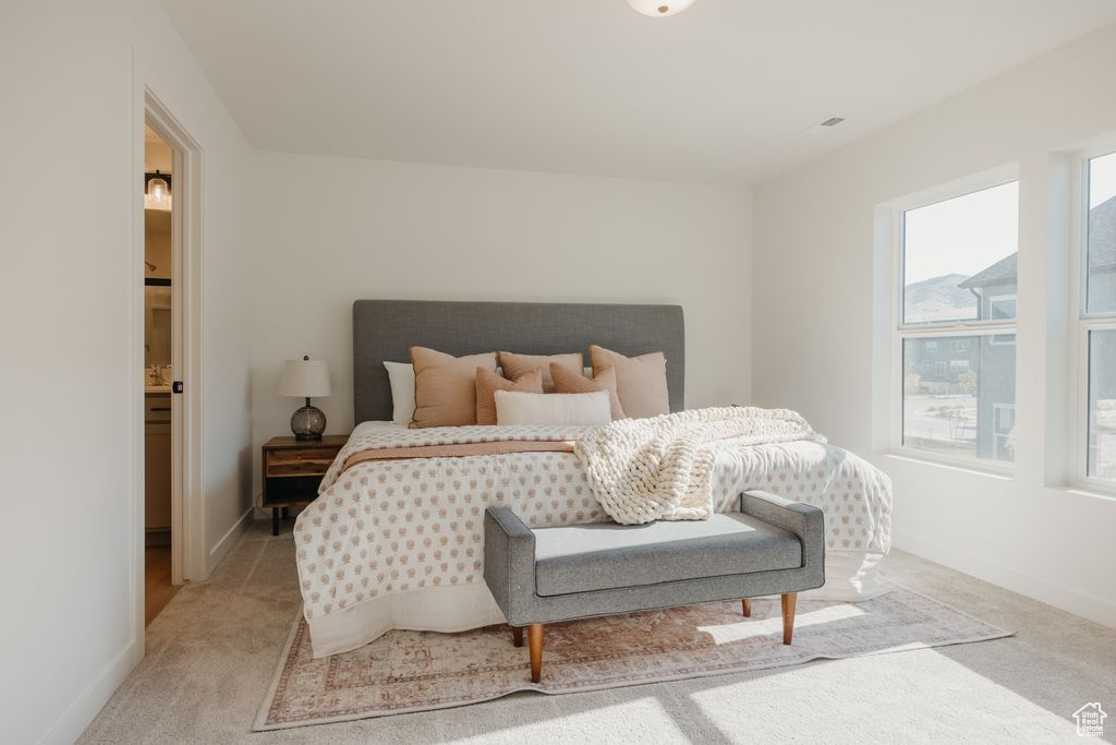 Bedroom with light carpet and baseboards