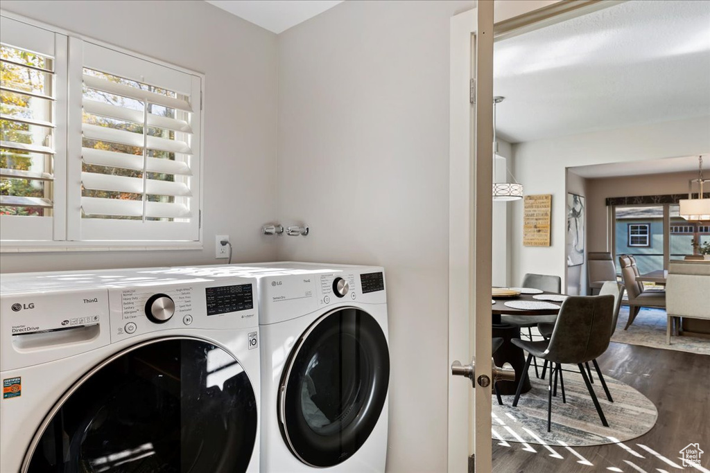 Washroom with independent washer and dryer, healthy amount of natural light, and dark wood finished floors
