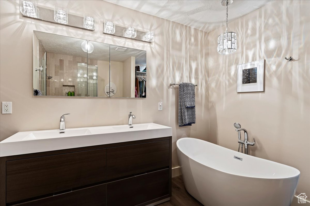 Full bathroom featuring a soaking tub, double vanity, and a shower