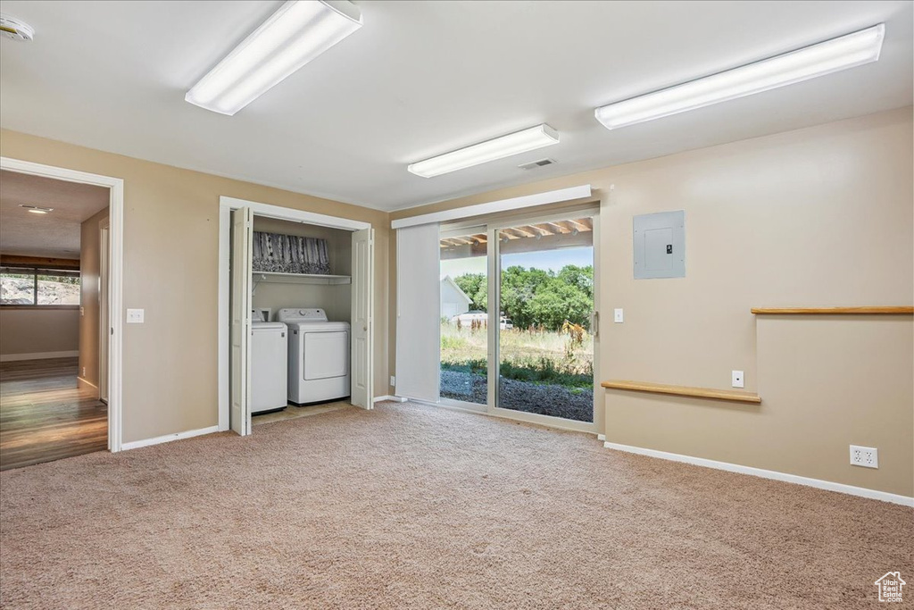 Spare room with electric panel, washing machine and dryer, carpet, and a smoke detector