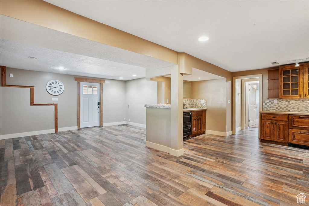 Kitchen with brown cabinetry, dark wood-type flooring, tasteful backsplash, and recessed lighting