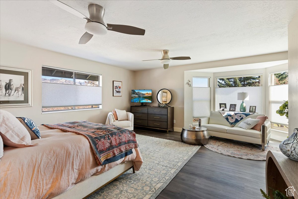 Bedroom with wood finished floors, a textured ceiling, and ceiling fan