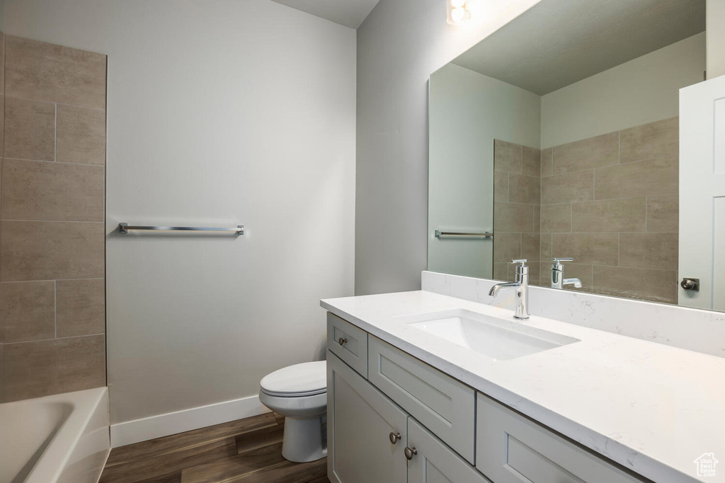 Bathroom featuring wood finished floors, vanity, and bathtub / shower combination