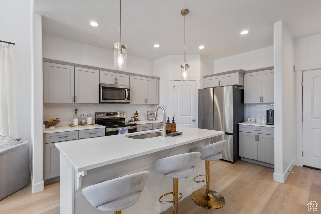 Kitchen featuring stainless steel appliances, gray cabinets, backsplash, and recessed lighting