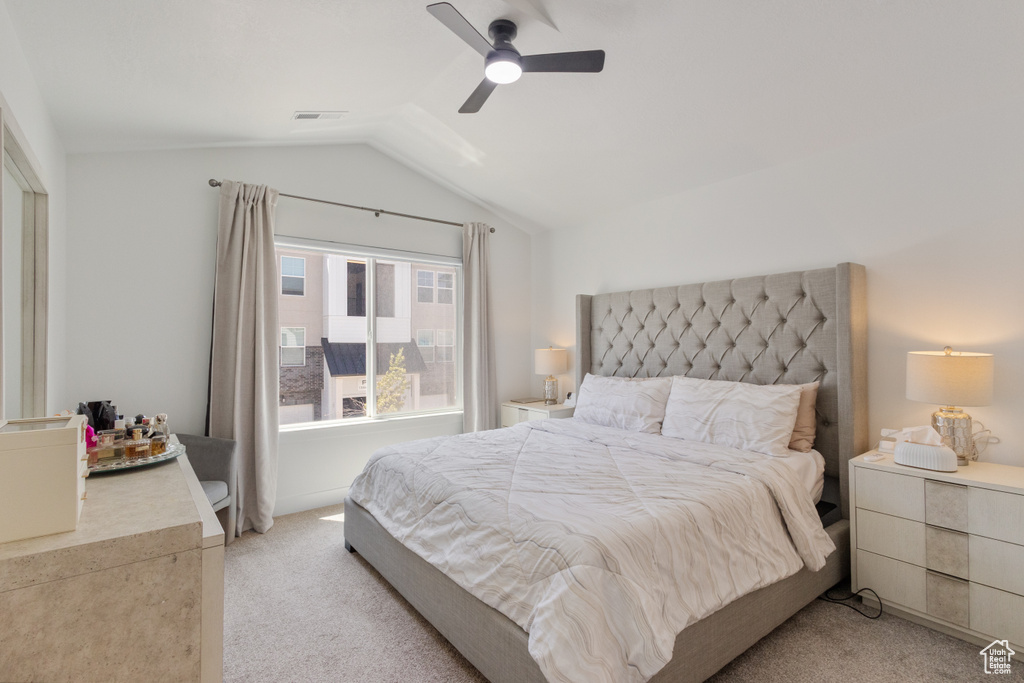 Bedroom with light colored carpet, lofted ceiling, and a ceiling fan