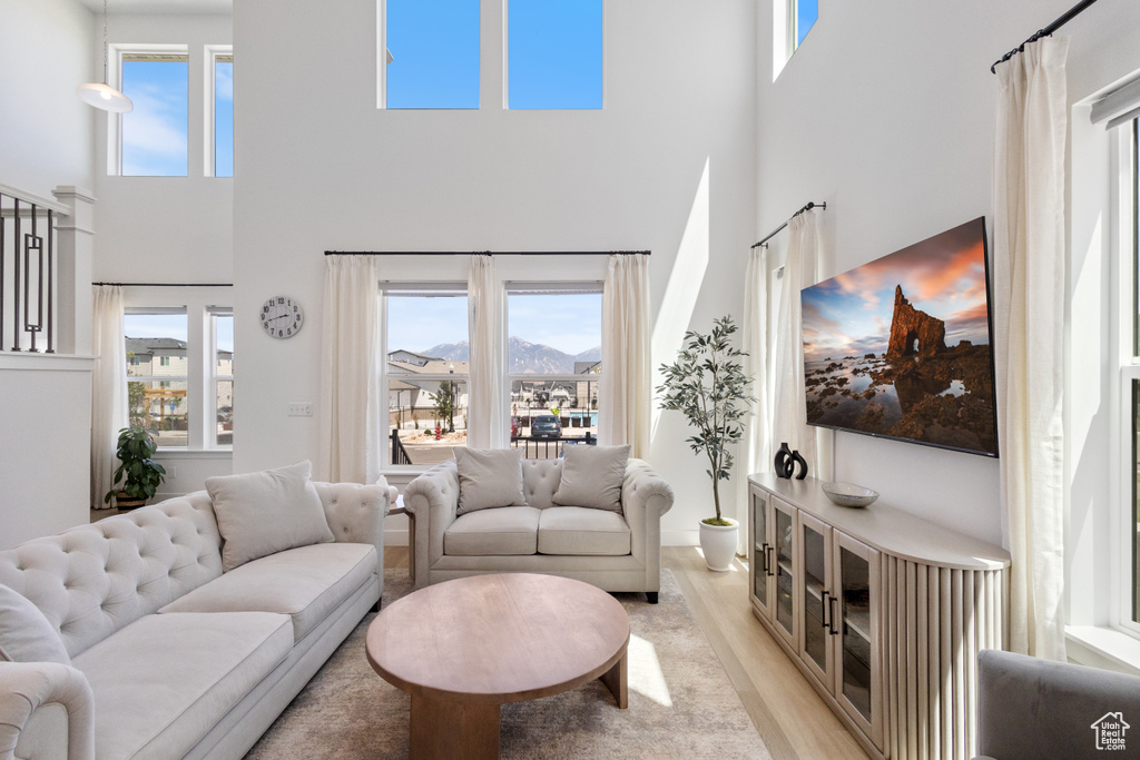 Living room featuring a towering ceiling and light wood-style flooring
