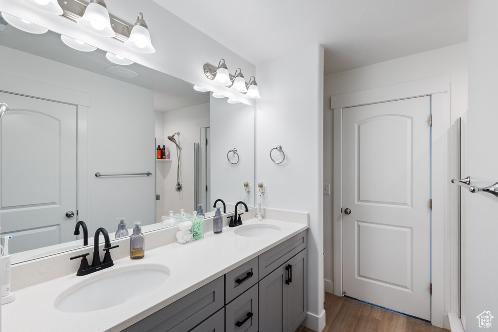 Bathroom with double vanity and wood finished floors