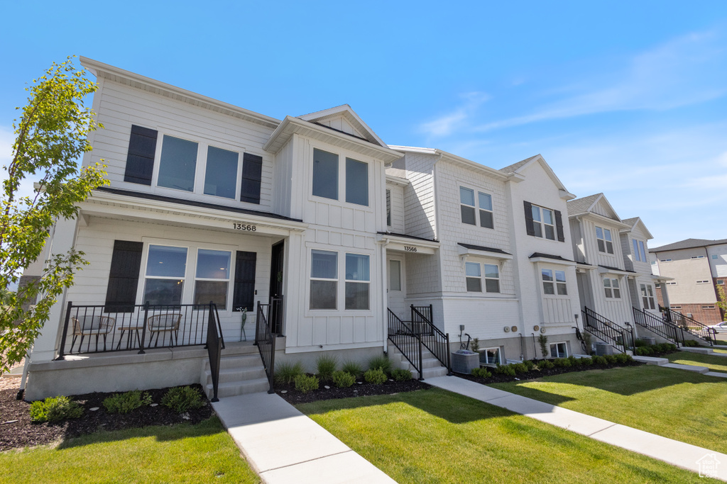 Multi unit property featuring board and batten siding, a residential view, a front lawn, and a porch