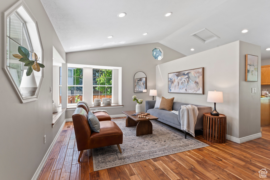 Living room with hardwood / wood-style flooring, vaulted ceiling, recessed lighting, and attic access