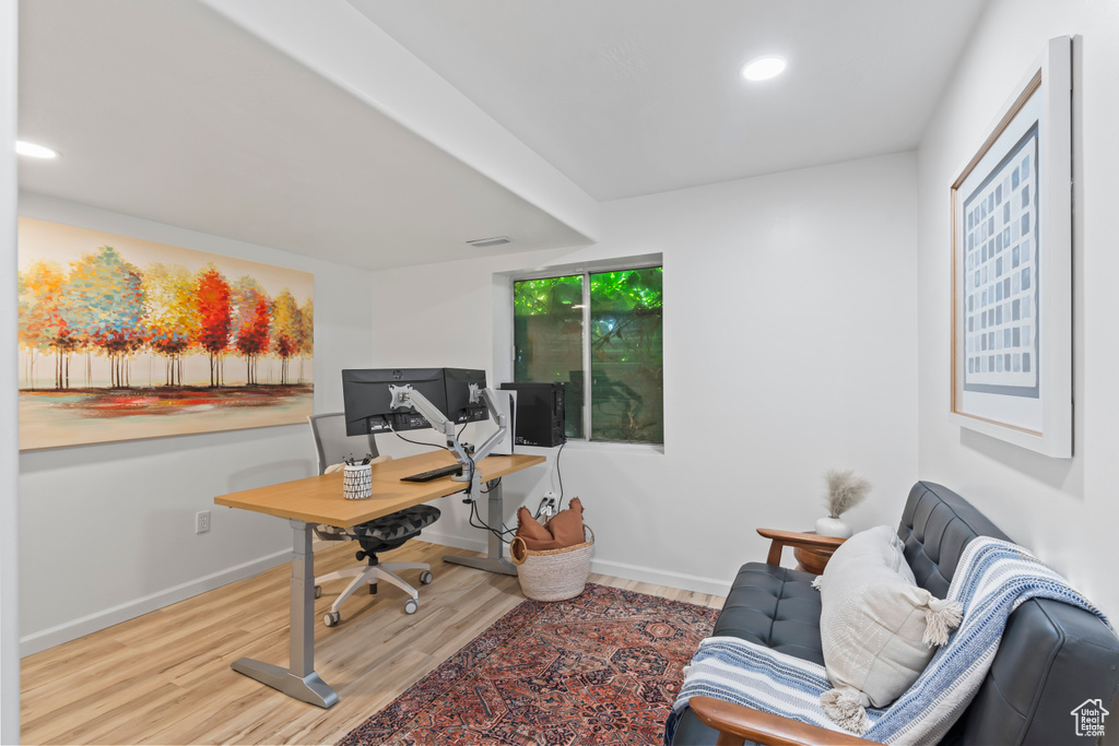 Office with wood finished floors and recessed lighting