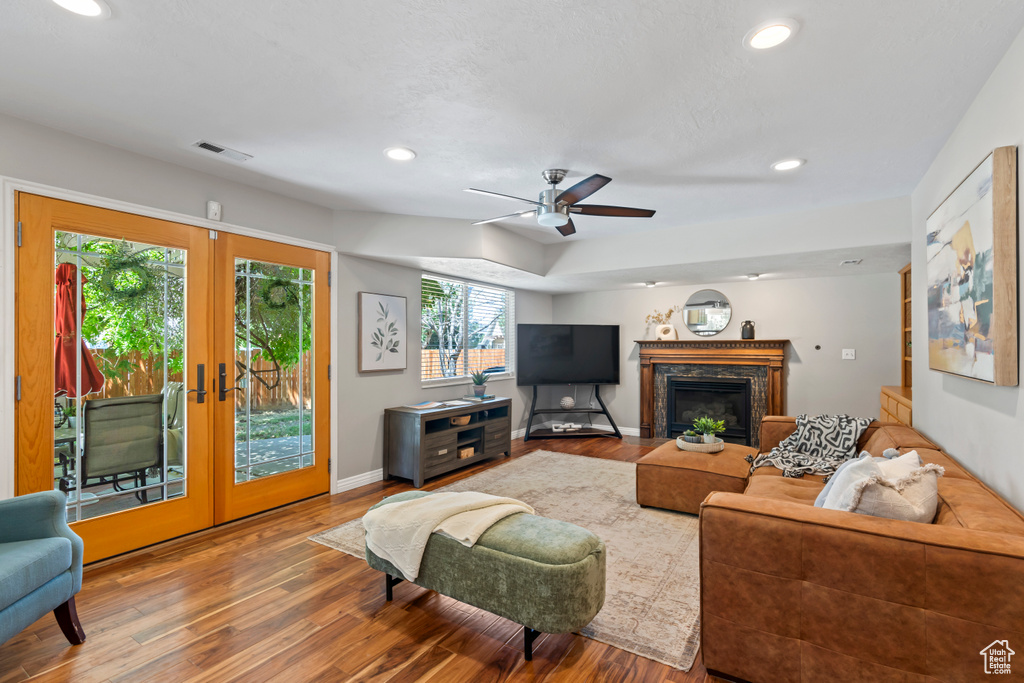 Living room featuring wood finished floors, recessed lighting, a ceiling fan, a high end fireplace, and french doors