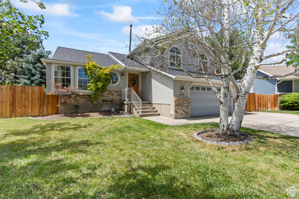 View of front of property with driveway, a garage, brick siding, roof with shingles, and stucco siding