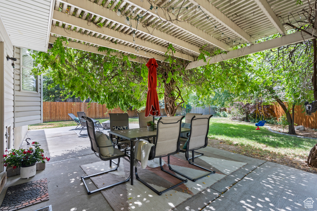Fenced backyard with outdoor dining area, a pergola, and a patio