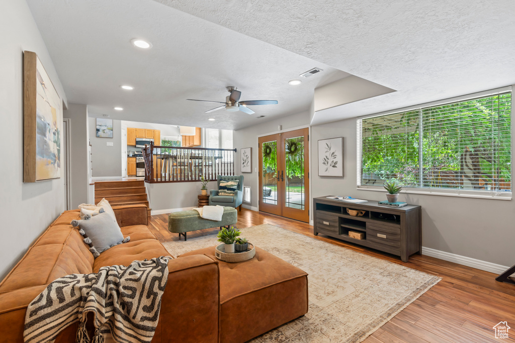 Living area with wood finished floors, recessed lighting, a textured ceiling, and ceiling fan