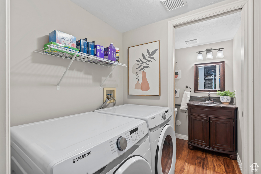 Washroom featuring independent washer and dryer and dark wood-type flooring