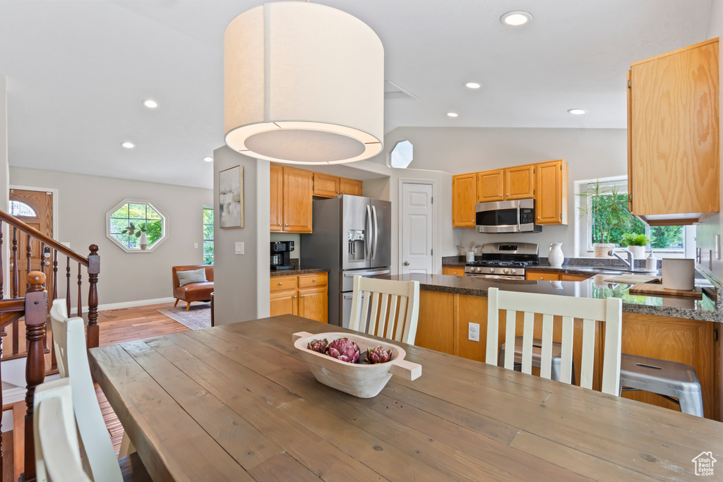 Dining room with lofted ceiling, recessed lighting, light wood-style floors, and stairway