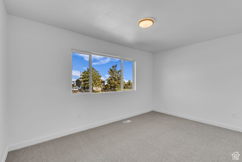 Carpeted empty room with baseboards