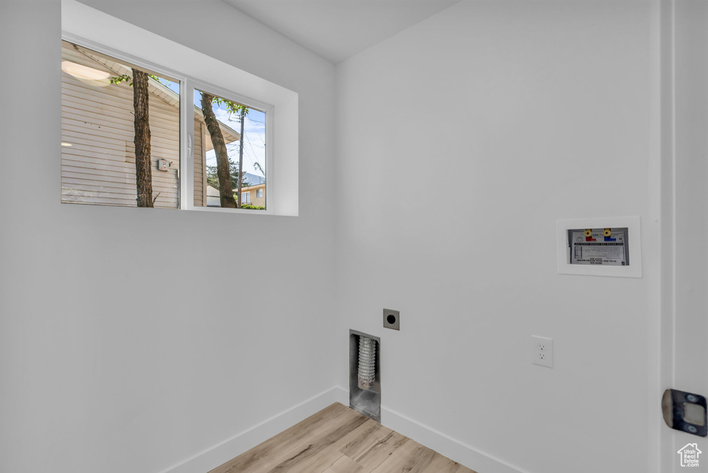 Laundry room featuring hookup for an electric dryer, hookup for a washing machine, and light wood-style floors